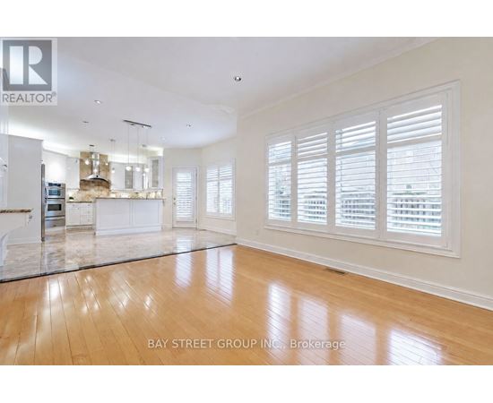 A spacious living room with wooden floors and white walls.