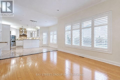 A spacious living room with wooden floors and white walls.