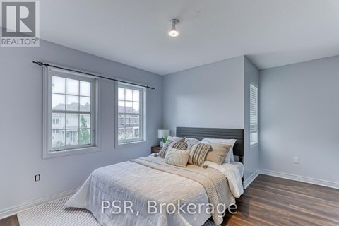 A bedroom with a large bed and a window with a view of the city.