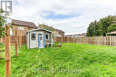 A small white shed with a blue door is situated in a grassy backyard.
