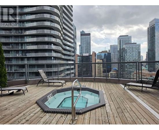 A rooftop with a hot tub and chairs overlooking a city skyline.