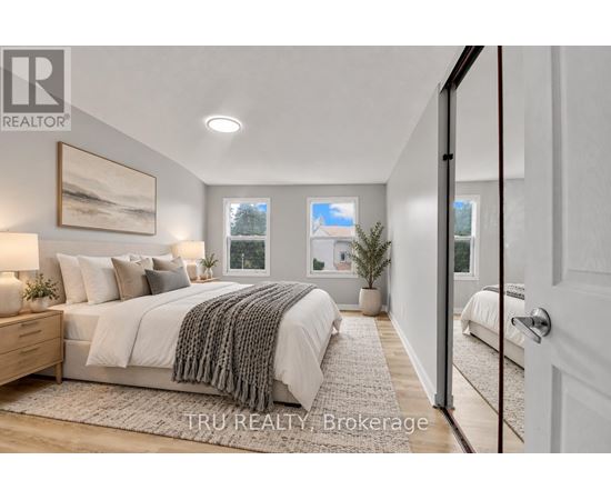 A bedroom with a large bed and a painting on the wall.