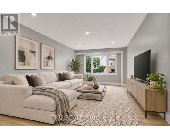 A modern living room with a large couch, a coffee table, and a flat-screen TV.