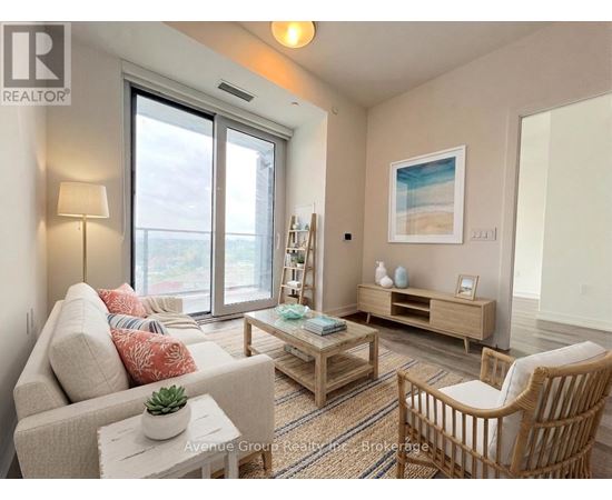 A living room with a couch, a chair, a table, and a painting on the wall.
