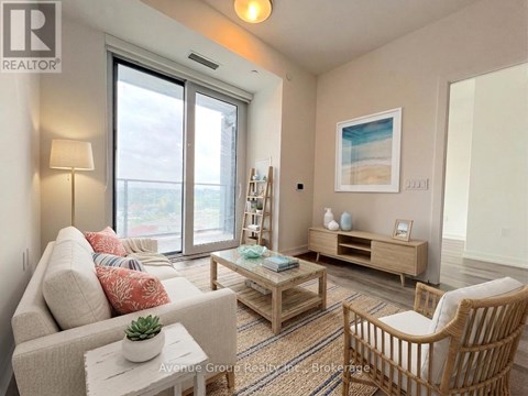 A living room with a couch, a chair, a table, and a painting on the wall.