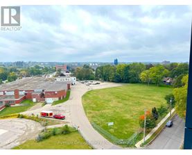 A view of a residential area with apartment buildings and a grassy field from a high vantage point.