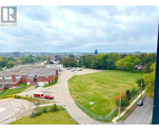 A view of a residential area with apartment buildings and a grassy field from a high vantage point.