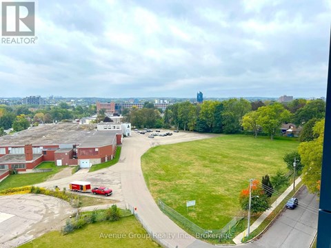 A view of a residential area with apartment buildings and a grassy field from a high vantage point.