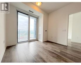 A spacious room with a sliding glass door leading to a balcony.