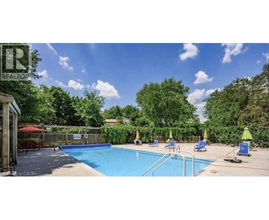 A pool surrounded by trees and a fence with a sign that says "REALTOR".