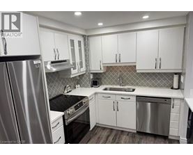 A modern kitchen with white cabinets and stainless steel appliances.