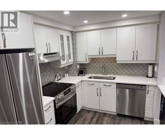 A modern kitchen with white cabinets and stainless steel appliances.