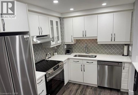 A modern kitchen with white cabinets and stainless steel appliances.