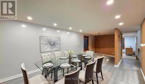 A dining room with a glass table and chairs.