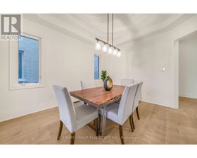 A dining room with a wooden table and grey chairs.