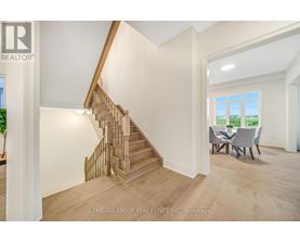 A spacious room with a staircase and a dining table.