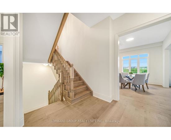 A spacious room with a staircase and a dining table.