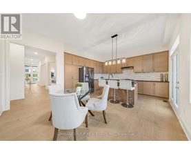 A modern kitchen with white chairs and a bar area.