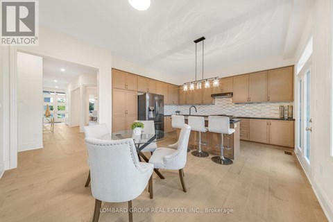 A modern kitchen with white chairs and a bar area.