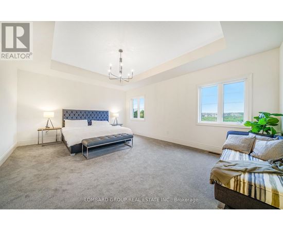 A bedroom with a large bed and a chandelier.