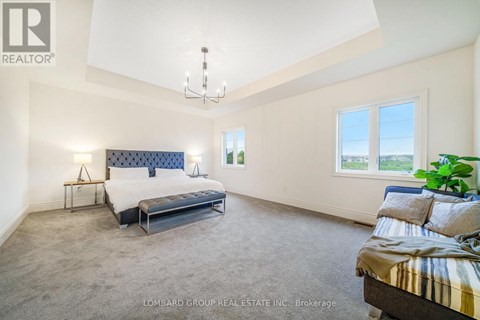 A bedroom with a large bed and a chandelier.