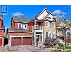 A large, two-story house with a red garage door is for sale.