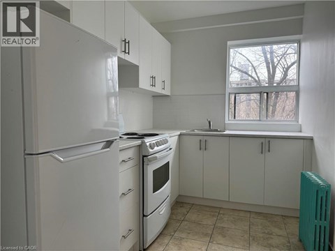 A kitchen with white appliances and cabinets.