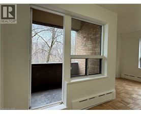 A room with a window that has a view of a tree and a building.