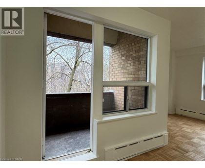 A room with a window that has a view of a tree and a building.