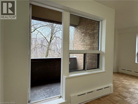 A room with a window that has a view of a tree and a building.