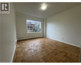 Empty room with wooden flooring and a window.