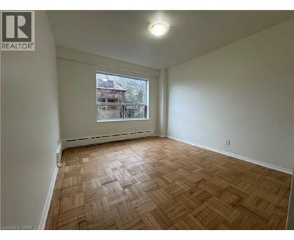 Empty room with wooden flooring and a window.