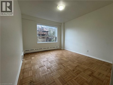 Empty room with wooden flooring and a window.