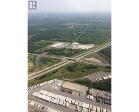 A large industrial area with a parking lot full of white containers.