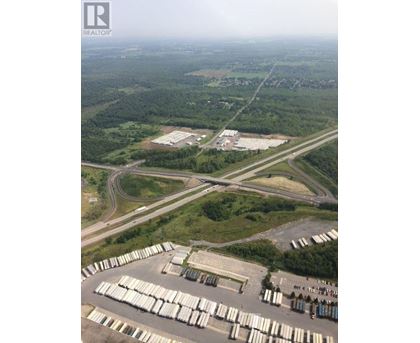 A large industrial area with a parking lot full of white containers.