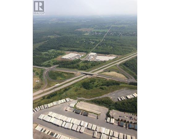 A large industrial area with a parking lot full of white containers.