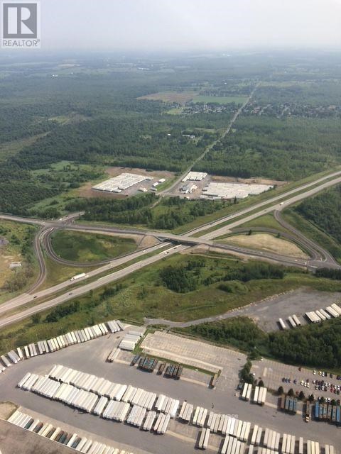 A large industrial area with a parking lot full of white containers.