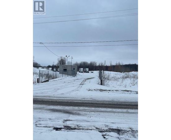 A snowy landscape with a building and power lines in the distance.