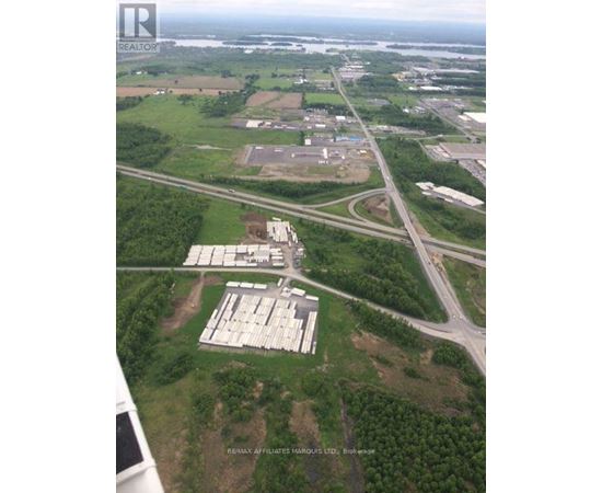 A bird's eye view of a large open field with a building complex in the middle.