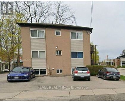 A two-story apartment building with a car parked in front.