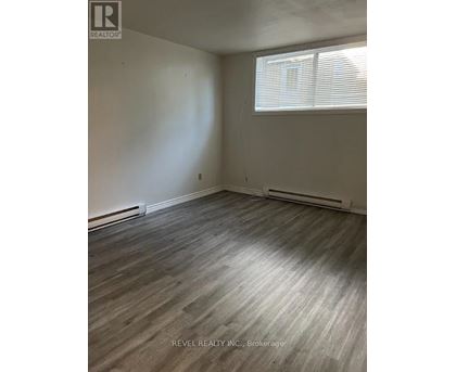 A room with a window and a wooden floor.