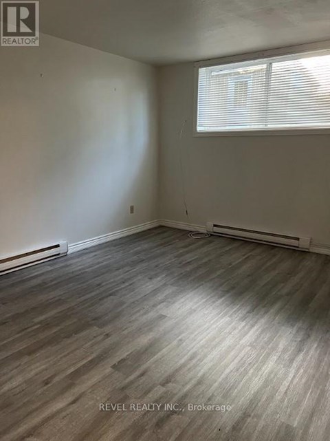 A room with a window and a wooden floor.