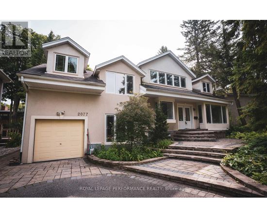 A house with a garage and a driveway in front of it.