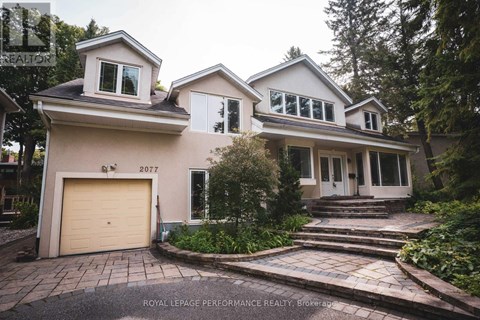 A house with a garage and a driveway in front of it.