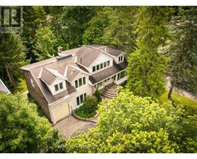 A large house with a brown roof surrounded by trees.
