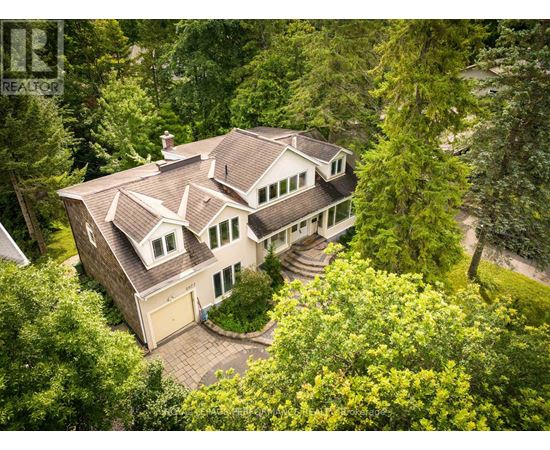 A large house with a brown roof surrounded by trees.