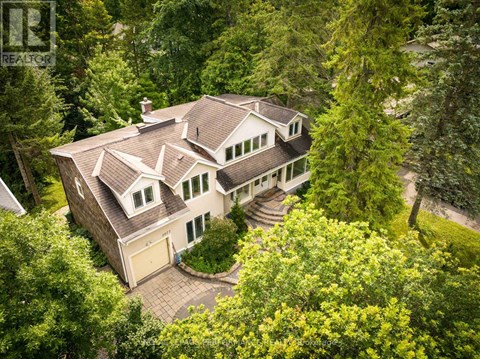 A large house with a brown roof surrounded by trees.