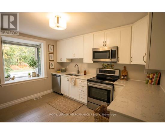 A kitchen with white cabinets and a marble countertop.