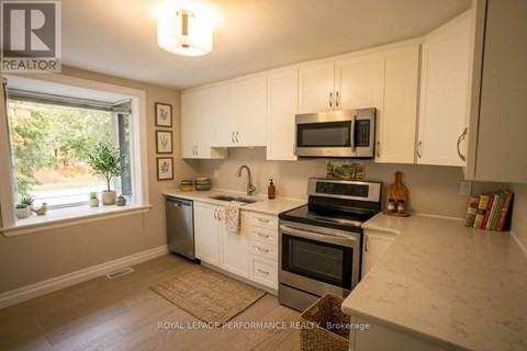 A kitchen with white cabinets and a marble countertop.