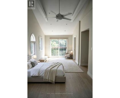 A bedroom with a large bed and a ceiling fan.